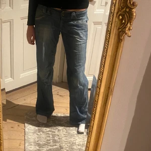 Lågmidjade jeans - Snygga lågmidjade bootcutjeans i mellanblå tvätt, smickrande passform och coola detaljer💕Jättebra skick! Storlek M skulle jag säga😇 Skriv vid funderingar och kolla in mina andra annonser🪩💞