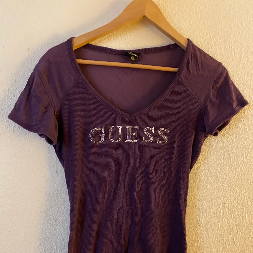 En lila t-shirt från märket Guess, i mycket gott skick 💖 storlek L men funkar för de flesta då den är stretchig ❤️ jag på bilder brukar bära M i toppar! . Toppar.
