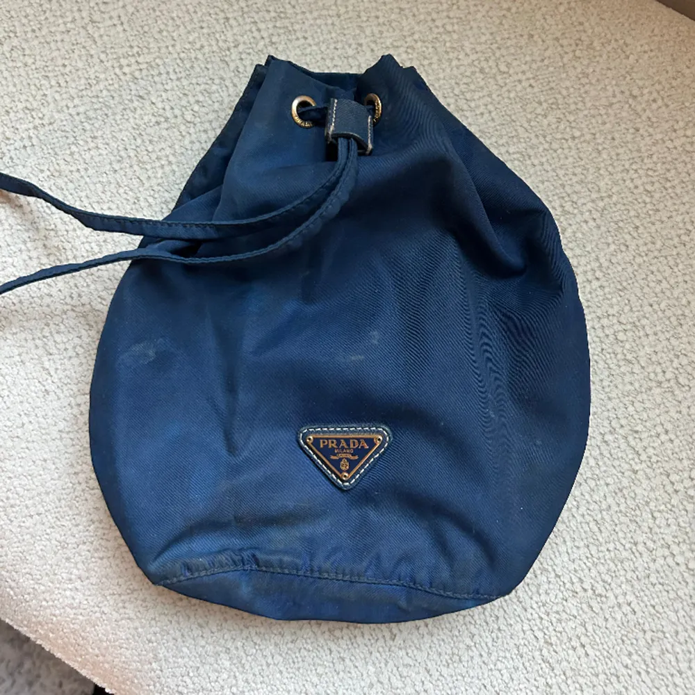 En Prada pouch i marinblå  Köpt på Vestairie Collective  Går jättebra att sätta till en kedja eller liknande, går att sätta till även en karbinhake.  Säljes pga för lite användning . Väskor.