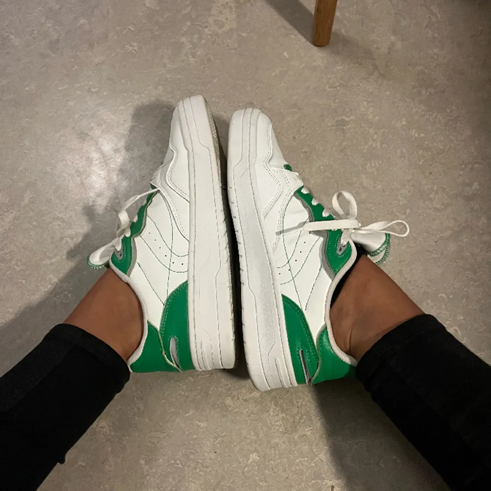 Vita sportiga sneakers i retro-stil med gröna detaljer och grov sula. Köpta på Zara, i storlek 41. Använda 3ggr bara så de säljs i fint skick! 🤍💚. Skor.