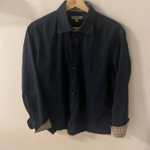 Burberry skjorta  - Marin blå burberry skjorta i L men sitter hur bra som helst på M. Öppen för byten och pris kan diskuteras. (Bra skick och ej skadad för mer bilder skriv)👍