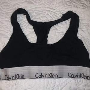 Svart Calvin Klein topp i strl XS. Behöver en tvätt därav priset. Aningen missfärgad i den vita kanten, så är mer åt det gråa hållet nu. 