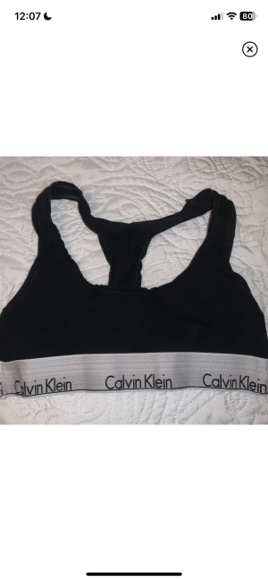 Calvin Klein topp - Svart Calvin Klein topp i strl XS. Behöver en tvätt därav priset. Aningen missfärgad i den vita kanten, så är mer åt det gråa hållet nu. 