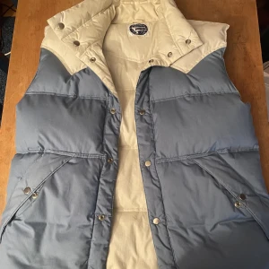 Äkta dun väst - En jätte fin dun väst som är tjock och bra för vintern. Inga knappar saknas. Helt oanvänd och ny.