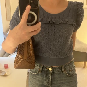 Fin blus från stories - Kort ärmad stickad blus med volang och hålmönster i en jätte fin blå färg som syns bättre på bild två, inköpt för något år sen men använd fåtal gånger så i bra skick:)