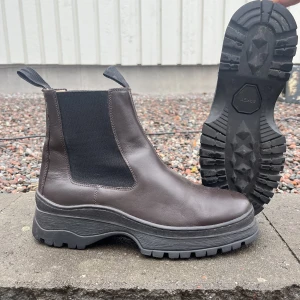 ARKET läderboots - Hej!  Säljer ett par boots från ARKET i strl 41 som jag köpte för ett år sedan. De är i mörkbrunt 100% läder med elastiska paneler på sidorna och en tjock gummisula.   Nypris: 2290 Mitt pris: 490 kr