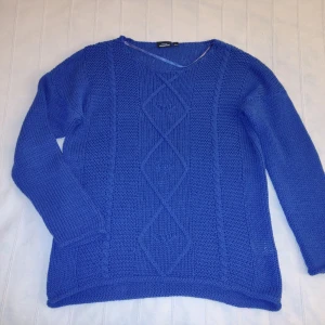 Blå/koboltblå stickad tröja - storlek 40/42 (XS-L) - Blå stickad tröja. 50% bomull och 50% akryl. Sparsamt använd och i bra skick (lite smånopprig på vissa ställen). Storlek 40/42 men passar fler storlekar beroende på hur man vill att den ska sitta.