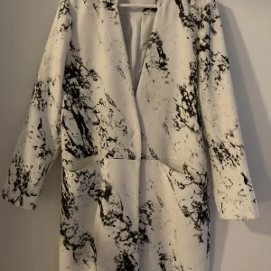 Kavaj, jacka, marmorerat mönster - Vit jacka med svart melerat mönster. Märke Gina Tricot, strl 40 Ett par mindre smutsfläckar, se bilder. 