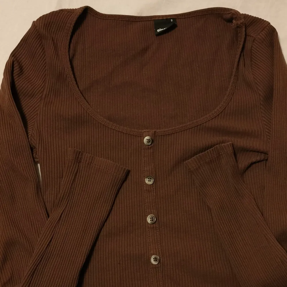 Brun långärmad tröja i ribbat material med knappar från Gina Tricot. Storlek S. Använda fåtal gånger. Tröjor & Koftor.