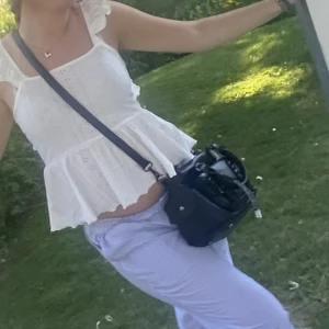 Vit topp - Säljer nu min jättegullig vita topp! Den är använd ett par gånger men ser ut som ny. Den är öppen i ryggen men har en snörning där bak. 