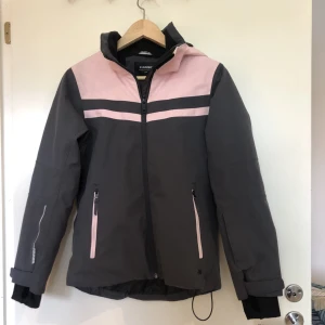 Skidjacka / vinterjacka - En skön skid-/vinterjacka i stl. 158. Från Everest, inköpspris 800 kr. I fint skick men något solkig på luvan, se bild 3.   Har snölås, innerficka, ficka på ärmen, avtagbar luva och 20 000mm vattenpelare.