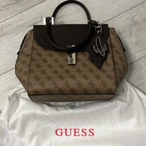 Vintage Guess väska - LÄS❣️❣️ Jättefin vintage guess väska köpt för 2000. I toppen skick!  Pris kan diskuteras! Man kan få fler bilder privat! Mått ungefär: 26cm x 24