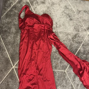 Röd balklänning - Klänningen har inte använts en ända gång men kedjan trasig så vi säljer den för billigare pris