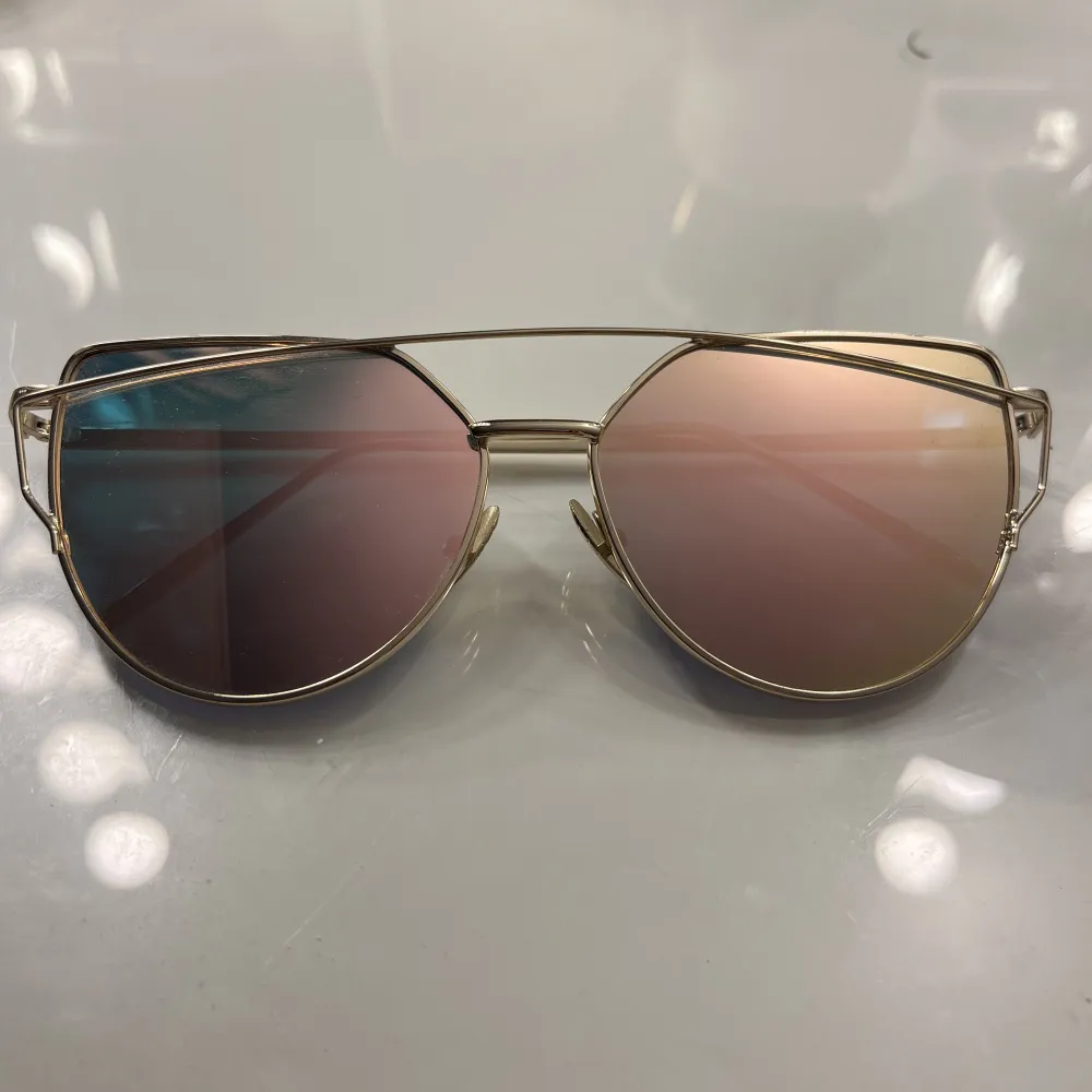 Svinsnygga guldiga solglasögon med rosa/blått glas! Är typ använda 1 gång☺️. Accessoarer.