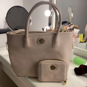 Väska  - Beige väska från Don Donna med tillhörande plånbok, använt få gånger för några år sedan. Använder inte längre så därför jag säljer den, ny skick och pris kan diskuteras men frakt ingår INTE. 