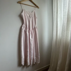 80s vintage rare Victoria Secret slip dress - Vintage Victoria Secret slip dress, rare 80’s! Otroligt fin, rosa satin med vackra detaljer & v-formad midja. Gold crown-label, storlekskappen har blekts, men skulle passa en XS-S!  Lagad i spetsen i fram, syns knappt.   Ger gärna fler bilder 🩷 