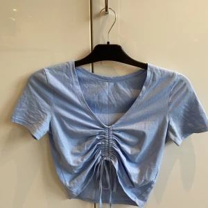 Topp  - Blå topp med snören som man kan dra åt 