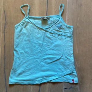 Babyblått linne - Jätte söt blått linne som jag säljer då den inte kommer till användning. Den har en liten krona i hörnet men några rhinestones över!