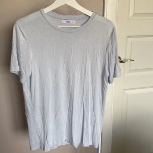 Ljusblå t-shirt - En ljusblå t-shirt från ellos i storlek 34/36. Knappt använd så i väldigt fint skick. Materialet är jätte skönt och tunt.💕