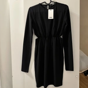 Basic svart klänning  - Helt oanvänd svart långärmad klänning med hål på sidorna av midjan väldigt elegant och skön på i storlek xs 