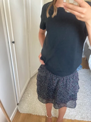 Volang kjol  - Fin volang kjol som är svart med lite andra färger💗 så fin och passar bra till sommaren, bra skick💘🤩 Om intresse skicka till oss på snap mer info i bion