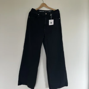 Wide leg jeans - Ett par utsvänga högmidjade svarta jeans från BikBok i storlek 32 i midjan längd 30. Helt nya men beställde i fel storlek och har glömt att lämna tillbaka. 