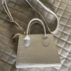 Väska - Säljer denna väska i nyskick. Superfin kritvit väska som man kan ha när man shoppar/ även ha i skolan. Hör av er vid intresse