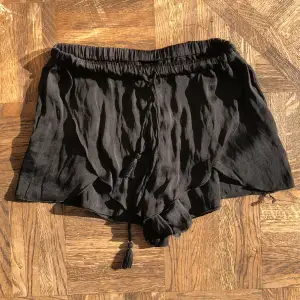 Svarta pyjamasshorts som jag köpte på Zara i Paris för flera år sedan. Dom är i ett satinliknande material, har resår i midjan med snören, och går lite omlott på främre delen av benen (se bilder). Nästan aldrig använda.