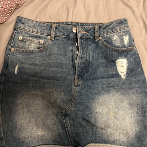 Jeanskjol  - En ljus och mörkblå kjol med lite slitningar på sidan från bikbok. Den är nästan aldrig använd