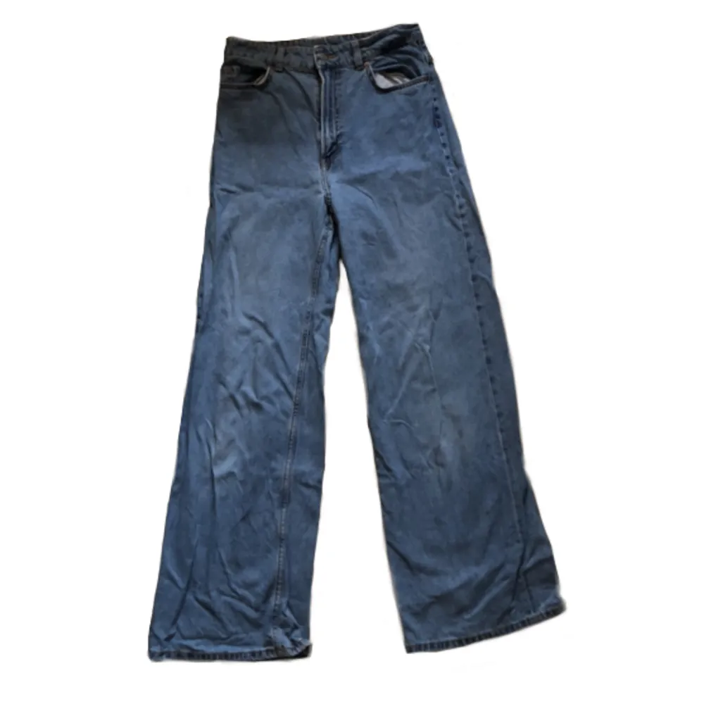 Högmidjade Blåa Denim Jeans från H&M i märket Divided byxorna är i bra skick och färgen är starkare blå i verkligheten  storlek 38 . Jeans & Byxor.