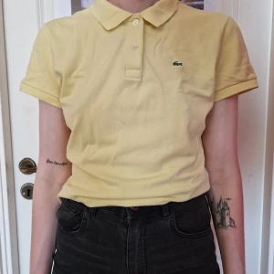 Lacoste piké - Ljusgul piké från Lacoste, strl 44, men ganska liten. Passar mig som har strl 38 vanligtvis (se bild).