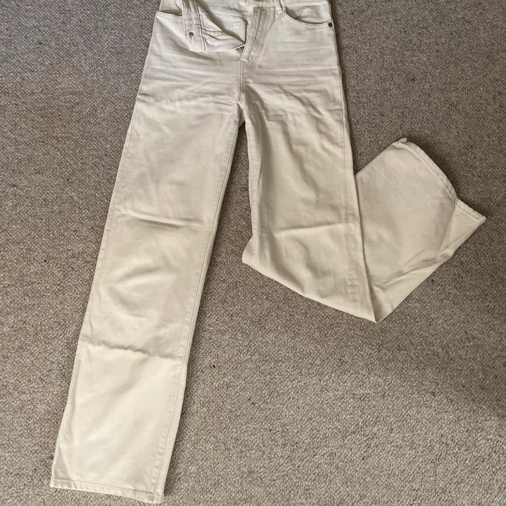 Fina vita jeans från Lindex som har använts ca 2 år. Inget slitage men säljer då det inte riktigt är min stil längre💓raka och vida i benen och i storlek 34💞lite blåfärgade på ena fickan från mobilskal men inget som syns jättetydligt💞skriv för fler frågor💞. Jeans & Byxor.