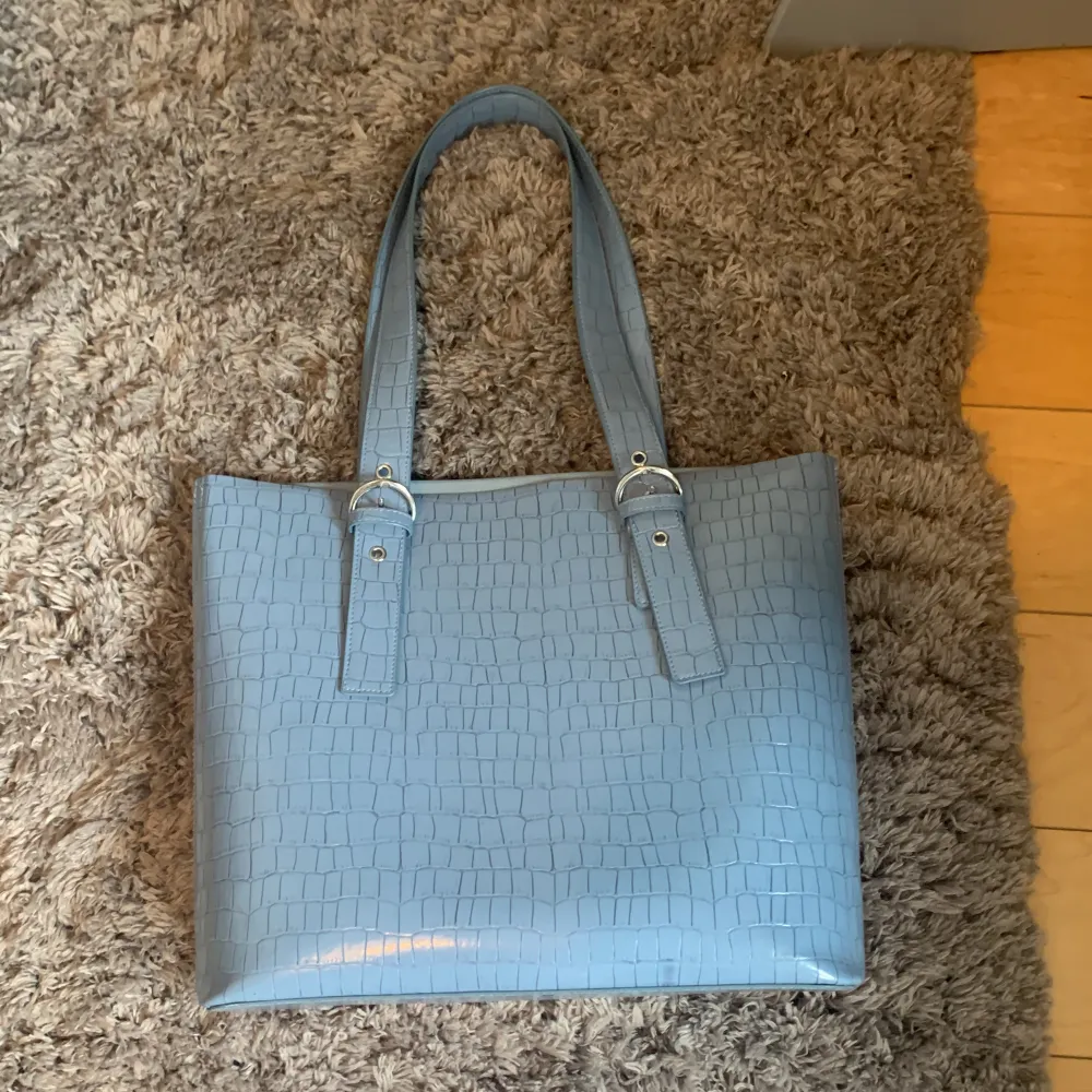 Säljer denna blåa handväskan, andvänd max 4 gånger. Den är ifrån H&M. Man får plats med mycket i den! Ungefär 33x20 cm. Väskor.