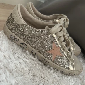 Next skor glittriga - Säljer dessa jätte fina golden goose inspererade skorna i storlek 37. Jag skulle säga att det är storlek 37,5 dom är lite större i storleken. Säljer på grund av dålig användning. Har använt fåtal gånger och bra skick. 💕