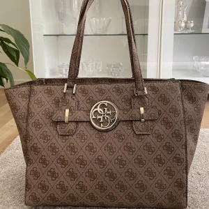 Guess väska  - En brun/beige Guess väska i fint skick! Lite slitet på handtagen därav priset. 🌸