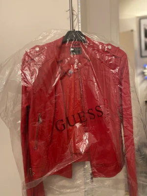 Röd skinnjacka från guess - En röd skinnjacka från Guess i storlek 38/40. Endast använd ett par gånger.