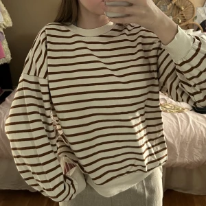 randig sweatshirt  - Randig sweatshirt/tröja från Pull&Bear i storlek XS. I bra skick! Färgen syns inte jättetydligt på bild, men den är vit och ränderna är bruna. Jättefin och perfekt för hösten! 