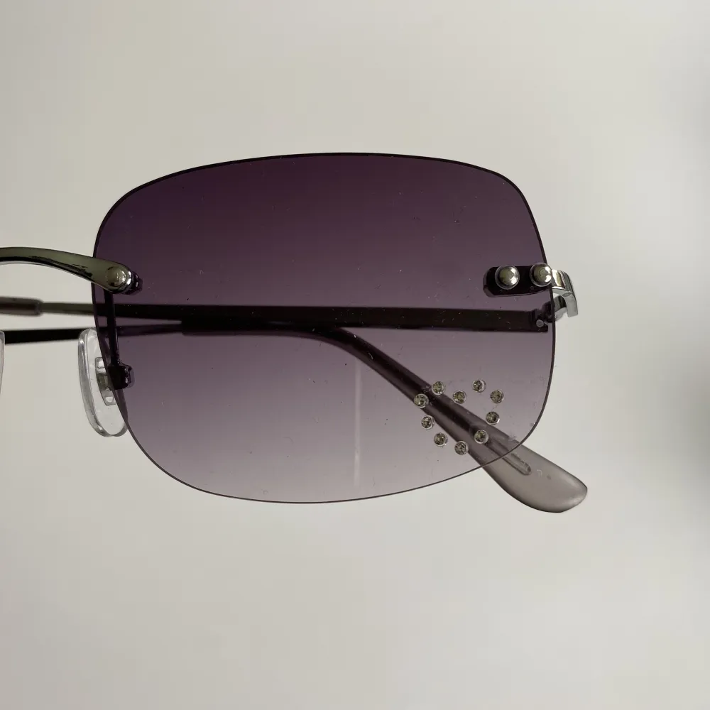 Coola solglasögon med en liten hjärtdetalj i strass. Glasögonen är använda men går att använda ändå.. Övrigt.