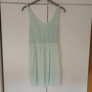 Ljusgrön klänning - Ljusgrön klänning. Vet inte vilket märke eller storlek det är (finns ingen lapp). Ganska genomskinligt material upptill, men funkar att ha nipplecovers under, alternativt tröja över. Materialet nertill är tjockare. Längd på klänningen är ca. 80 cm.