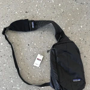Patagonia ”slingbag” - Helt ny med tagg kvar! Säljes då jag ej gillade slingshot väska. 2 stora fack, ett mindre fack i största facket.