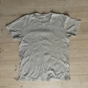 Grå T-shirt från East West - Grå T-shirt från East West, köpt på Brothers. Storlek M Sparsamt använd och i gott skick