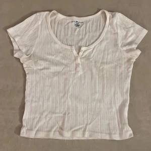 Vit babytee Brandy Melville - Jättegullig vit babytee med knappar från Brandy Melville. Mjuk och skönt material! Onesize men skulle säga som en S. Mycket bra skick 🤍