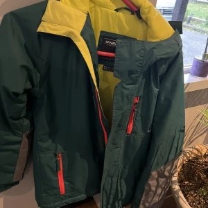 Skidjacka - Fin skidjacka. Grön med gula och röda detaljer. 