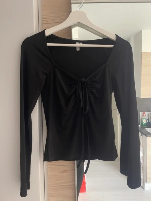 Svart långärmad - Jättefin topp från Nelly med knytdetalj fram! 