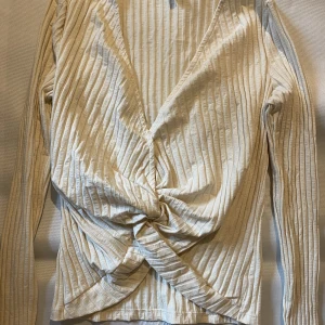 Tröja  - Vit/beige långärmad tröja ifrån nelly, endast använt en gång säljs då den inte kommer till användning, fin Knut runt navel som ger en fin form.  