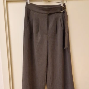 Grå Kostymbyxor - Grå plisserade kostymbyxor med inbyggt skärp  Brand: NA-KD  Size: 36