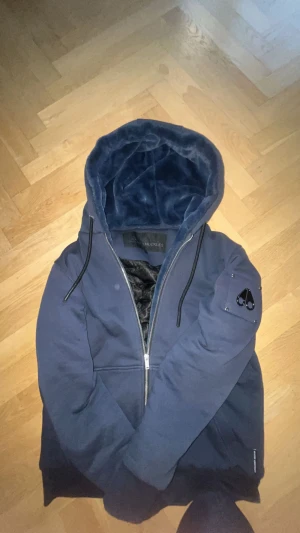 Moose knuckles hoodie - Vadderad hoodie fran Moose Knuckles i mörk blå. Använd tre gånger så den är i väldigt bra skick. Funkar både för hösten och vinter ❄️❄️🍁🍂🍁nypris 5000kr. Size M. DET ÄR INGEN FLÄCK PÄ JACKAN SER BARA UT SÅ 