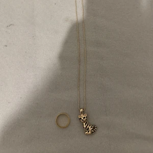 Halsband + ring - Säljer halsband + en ring, halsbandet har en tiger och ringen är gold med silver där inne. Säljer ej separat!!        STÅR EJ FÖR FRAKTEN 