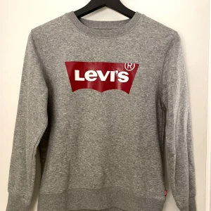 Levi’s sweatshirt - Säljer min Levi’s tröja då den blivit för liten. Fint skick förutom ett litet streck på E:et men syns knappt. Nypris 500kr. Strl 12A/ 152cm. Frakten ingår vid snabbt köp.