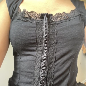 Marks & Spencer korset topp - Jättefin korsett liknande topp med snygga detaljer i mitten och spets uppepå. Väldiga charmiga kort ärmar och sitter väldigt fint, köpta secondhand men inga defekter 